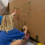 Kinderen tekenen op een doos
